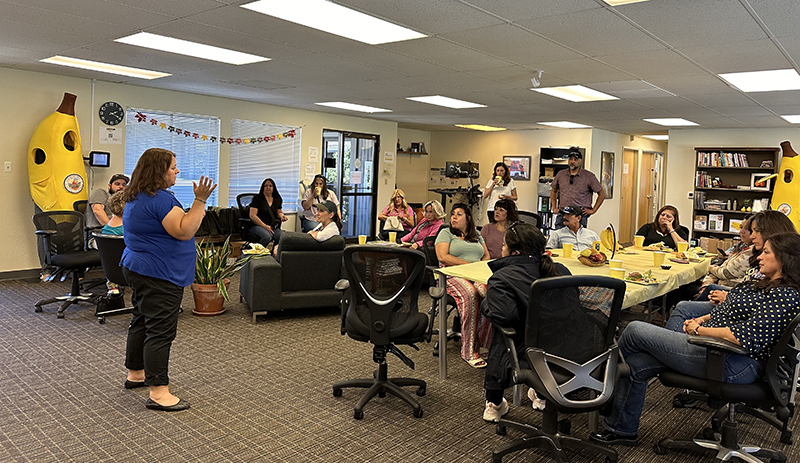 Erin speaking to a crowd at the FruitGuys office