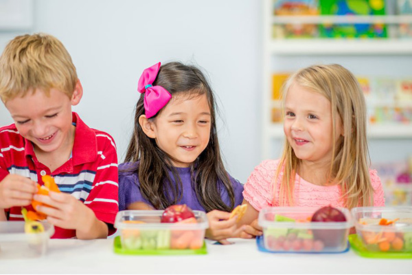 Smiling kids eating fruit